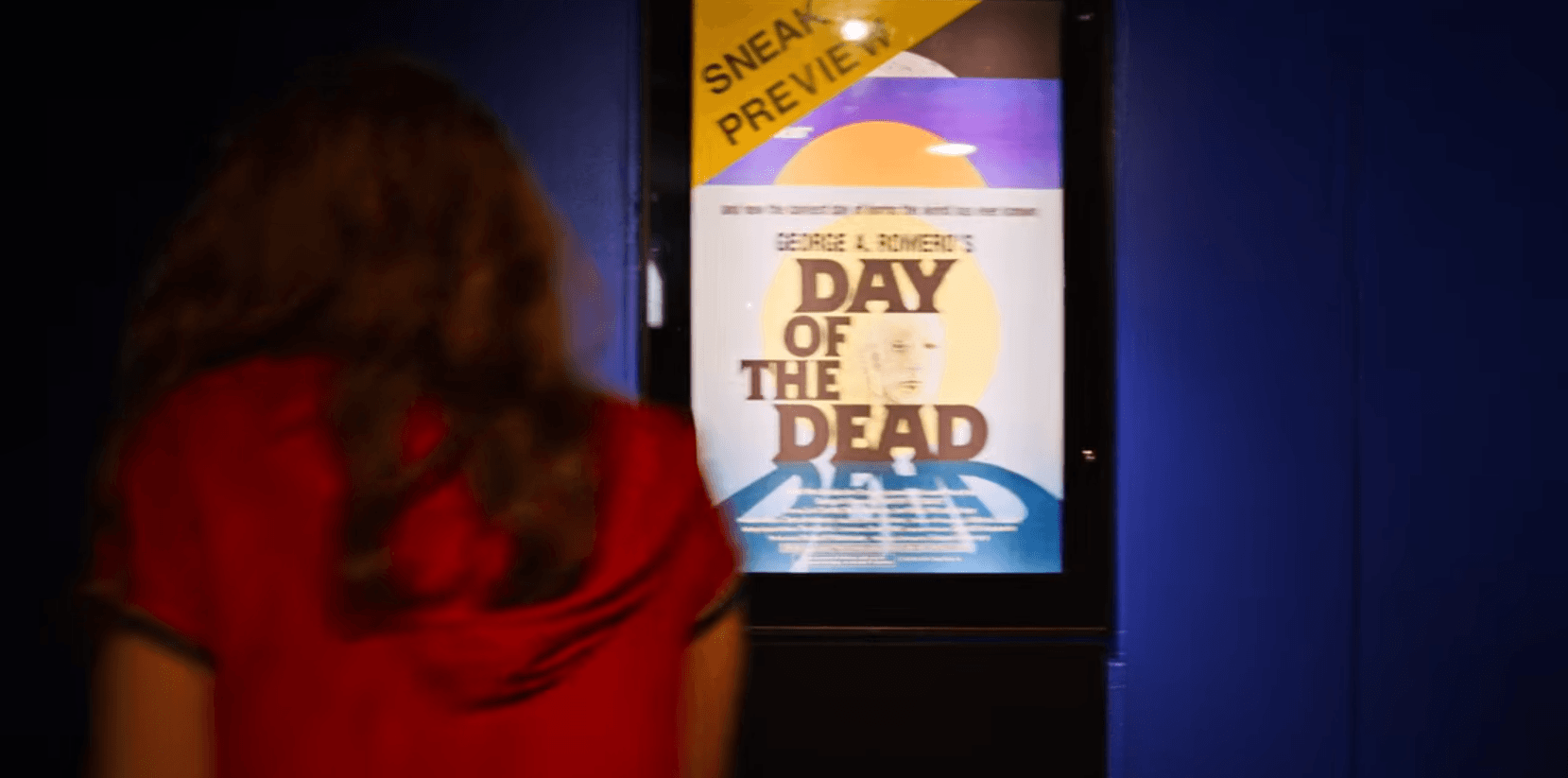 Max entra na sala de cinema que está passando Dia dos Mortos