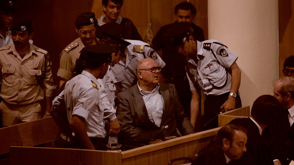 John Demjanjuk senta no banco dos réus em seu julgamento em O Monstro ao Lado